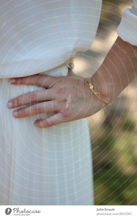 Hand mit goldenem Armreif Braut Hochzeit Finger plissee falten Faltenrock Seide seiden weiß Creme Bluse Sommer Natur