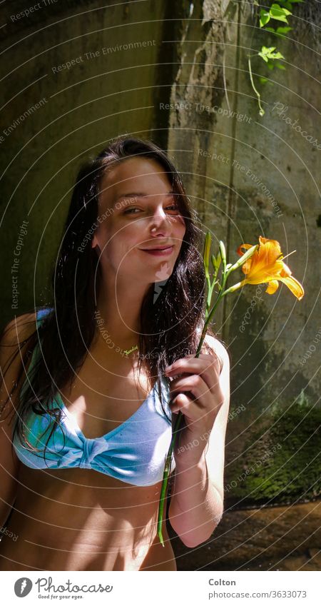 Mädchen, das mit einer Blume lächelt Model Baden Anzug Frau Sonne Gras Roséwein