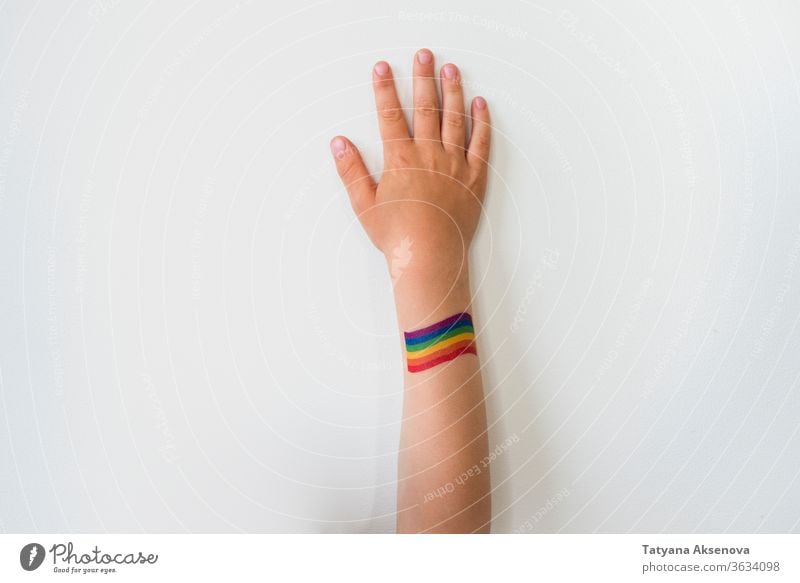 Aufgerichtete Kinderhand mit Regenbogen-Tattoo der LGBTQ-Stolzflagge Fahne lgbtq Freiheit schwul lesbisch Homosexualität Symbol Hand angehoben Rechte farbenfroh