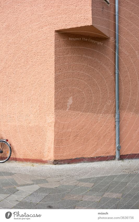 Hausecke mit Fahrrad und Abflußrohr Ecke Rohr Platten rosa grau braun Dreieck Farbe Leere Frage Schattierung Unterstand kleiner Balkon Muster Fußweg