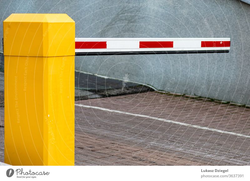 Weiße und rote Eingangsschranke auf einem gelben Pfosten Barriere Außenaufnahme parken Parkeingang Verkehr Parkhaus rot und weiß Gate Parkplatztor Farbfoto