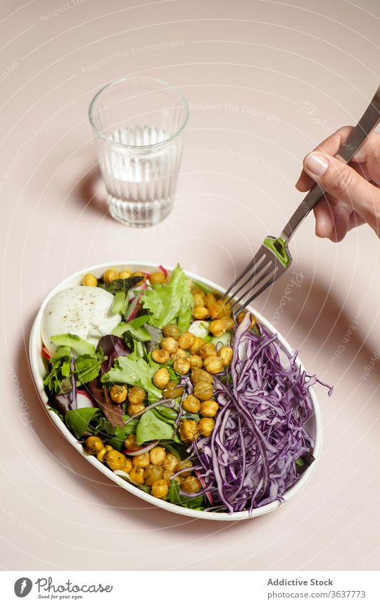 Frau isst Salat mit Kichererbsen Salatbeilage Ernährung Vegetarier organisch Lebensmittel Gesundheit frisch Mahlzeit Gemüse Diät Kohlgewächse rot mischen Glas