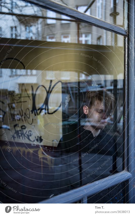 ein Mann steht hinter einer Glasscheibe im Treppenhaus Berlin Prenzlauer Berg Stadt Außenaufnahme Hauptstadt Altbau Haus Stadtzentrum Altstadt Tag Farbfoto