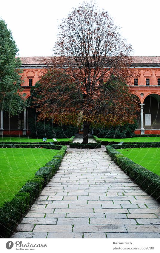 Ein Backsteinhaus in Mailand mit grünem Vorgarten. Italien Europa Haus Architektur Bauwerk alt Stadt Zuhause Fenster Dach historisch Fassade Himmel Weg