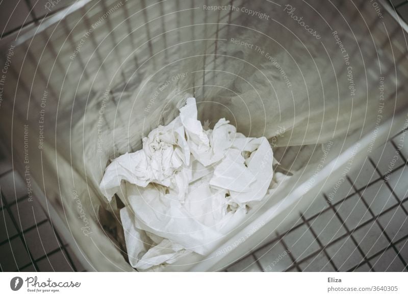 Papierhandtücher im Mülleimer in einer öffentlichen Toilette Hände abtrocknen Hände waschen Sauberkeit weiß Hygiene Abfall Papiermüll gefließt Badezimmer