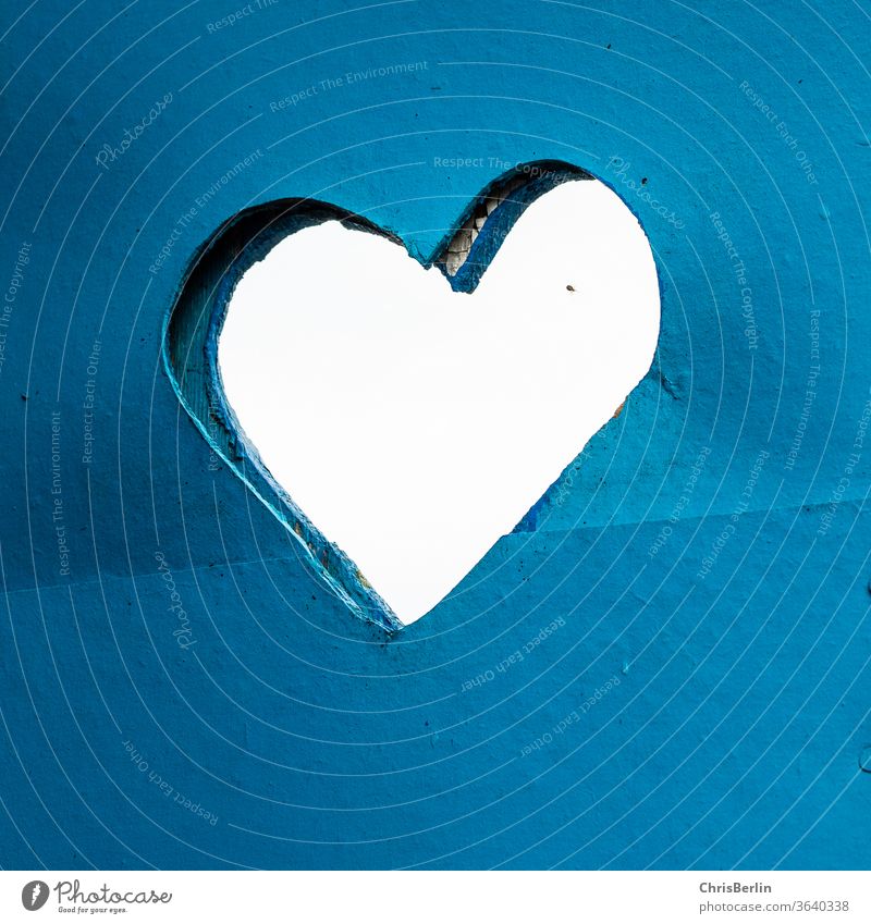 Eingesägtes Herz in einer blauen Holztür eingesägt stilles Örtchen quadratisch