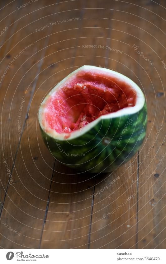 ausgehöhlte melone auf einem holzboden Melone Wassermelone Frucht gesund lecker aufgegessen Fruchtfleisch innen saftig gesunde Ernährung Durstlöscher Sommer
