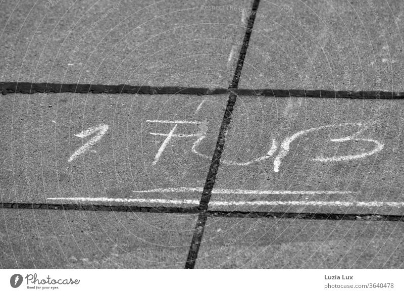 Kreidebeschriftung auf dem Bürgersteig, 1 Fuß und weiter geht es Hüpfspiel Kreidezeichnung Kinderspiel Stadt urban Schwarzweißfoto Linien Spielen Außenaufnahme