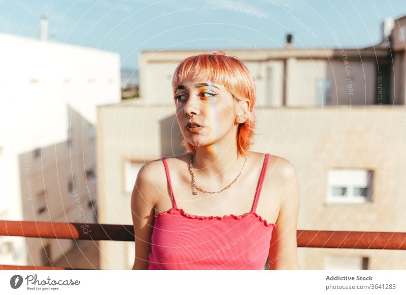 Frau steht auf einem Dach und schaut weg tausendjährig Regenbogen expressiv rosa Haare anders Sommer Reling Großstadt fettarm Freiheit urban emotionslos Stil