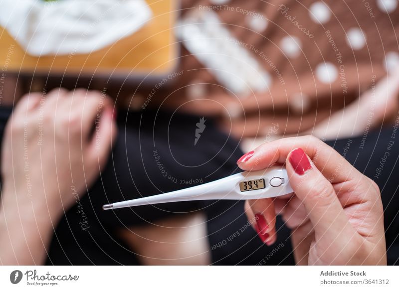 Nutzpflanzenfrau mit Thermometer auf dem Bett Temperatur krank Frau kalt heimwärts Krankheit ertragen Grippe sitzen flach unwohl Schmerz Pflege heimisch