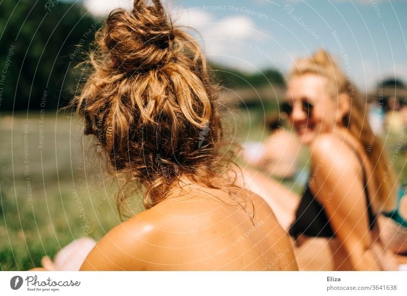 Zwei junge Frauen im Bikini beim Sonnenbaden im Sommer. sonnen Sonnenschein Baden sommelich Freundinnen von hinten Sommerurlaub Urlaub zuhause See Sonnenlicht