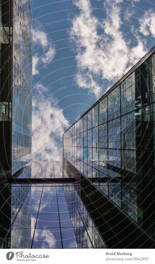 Aufblick auf ein Gebäude mit reflektierenden Glasfenstern Winkel Architektur Hintergrund blau Business Großstadt Stadtbild Wolken wirtschaftlich korporativ