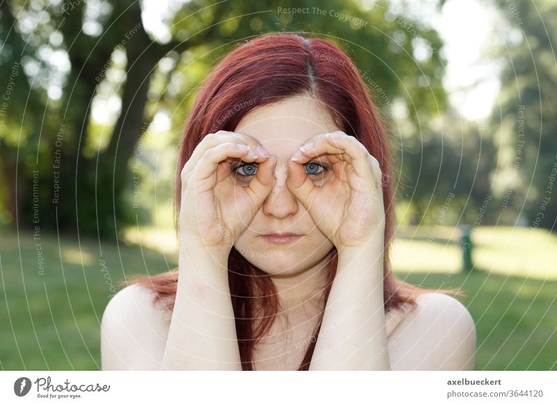Hände, die Ferngläser imitieren beobachten Suche Blick Überwachung sehen Fernglas Brille spionieren Frau Mädchen jung im Freien Natur Porträt rote Haare Sommer