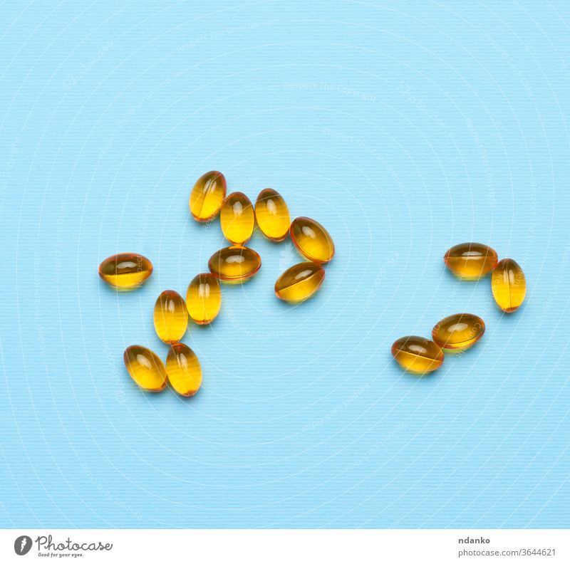 Fischöl in ovalen gelben Kapseln auf blauem Hintergrund Ernährung Gesundheit Ergänzung Medizin Tablette Vitamin Erdöl Omega medizinisch ernährungsphysiologisch