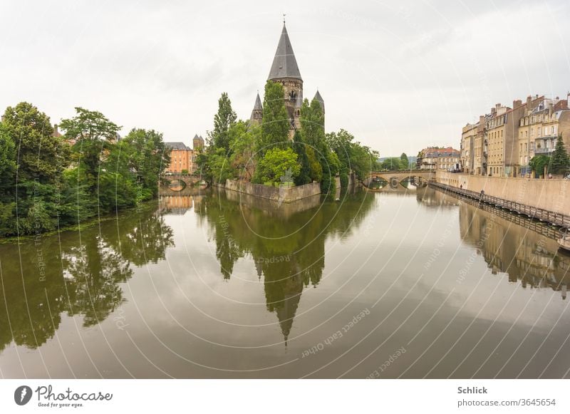 Lothringen Temple Neuf in Metz gesehen von der Pont des Morts bei Regenwetter Mosel Stadt Fluss Frankreich Spiegelung Wasser Kreise Himmel bedeckt grau Häuser