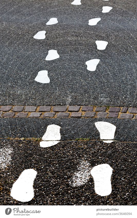 Weiße Fußspuren auf dem Asphalt der Straße Fußabdrücke weiß Außenaufnahme Menschenleer Schilder & Markierungen Farbfoto Verkehr Wege & Pfade grau Verkehrswege