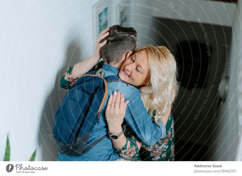 Mutter küsst Söhne zu Hause auf Treppenstufen auf die Wange Sohn Kuss Umarmung Inhalt modern Teenager Eltern Augen geschlossen Schritt Bonden gemütlich Schule