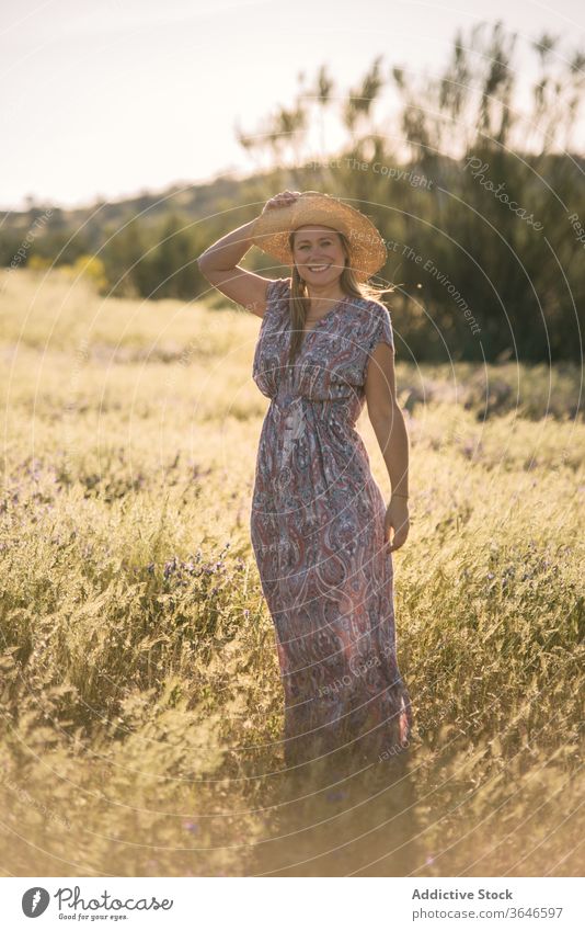 Charmante Frau auf der grünen Wiese Sommer Feld genießen Kleid sonnig Strohhut Lächeln Natur heiter Urlaub trendy stehen Freiheit Wochenende tagsüber Freude