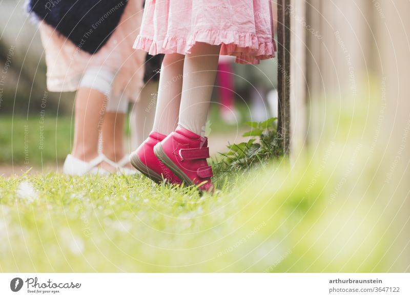 Kind steht auf Zehenspitzen vor einem Zaun kind Kinder kindheit wachsen Mädchen Menschen Wachstum erwachsen werden Spielen neugier klein natur Sommer freude