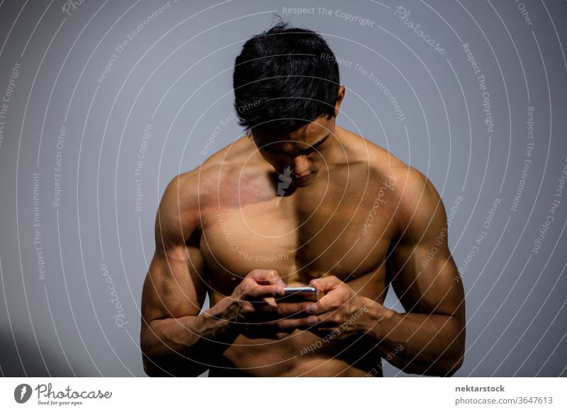 Fitness-Modell mit Mobiltelefon Nam Vo männlich asiatisch muskulös Muskeln Stärke Sport sportlich Studioaufnahme menschlicher Körper Physis Torso Mann ohne Hemd