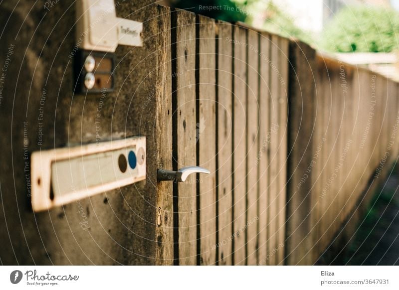 Ein Gartentor aus Holz. Eingang. wohnen Klingel Briefkasten Häusliches Leben Tür Eingangstor besuchen Haus Namensschild Zaun Klinke Türklinke