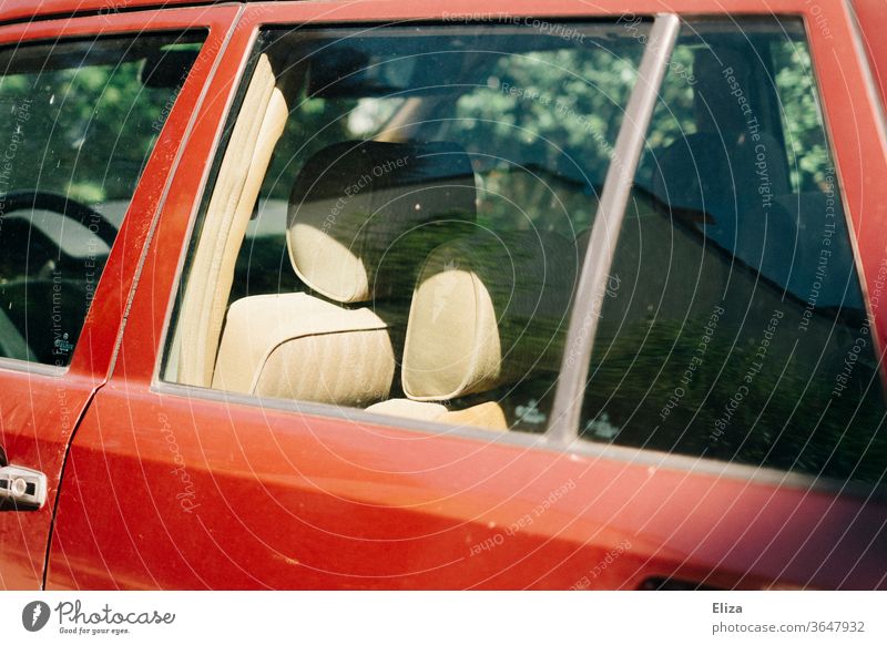 Blick in ein altes rotes Auto mit beigen Ledersitzen Fahrzeug retro PKW Verkehrsmittel innen innenausstattung Sommer Autofenster Scheibe Fensterscheibe