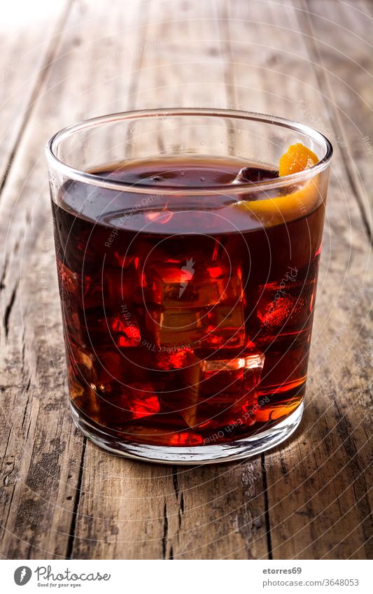 Boulevardier-Cocktail aus Glas auf Holztisch alkoholisch Getränk boulevardier campari kalt trinken Eleganz frisch Frucht Eis mischen orange rot rustikal
