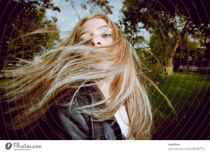 Blondhaarige Dame posiert im Park und tanzt mit ihrem langen blonden Haar in der Luft im Freien Menschen Natur Porträt Erholung Erwachsener Mode niedlich Kind