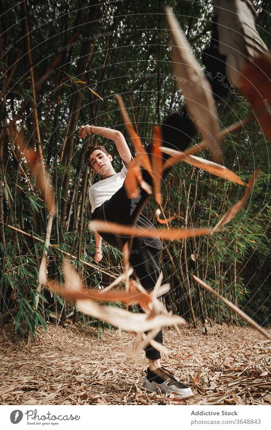 Fitness-Jugendlicher Freestyle-Tänzer macht Trick im Wald Aktivität Energie Erholung Tanzen Gleichgewicht üben Dickicht modern professionell Arm angehoben
