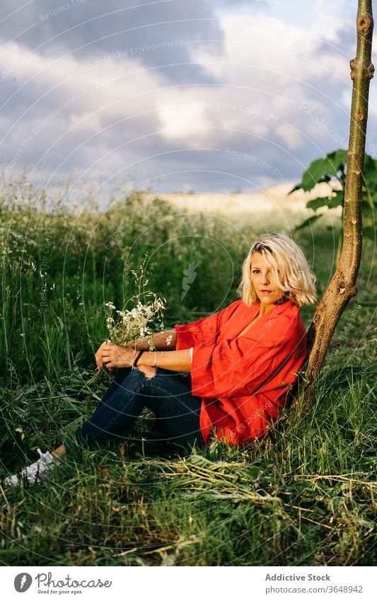 Entspannte Frau ruht sich auf Grasfeld aus Landschaft grasbewachsen Kofferraum Natur ruhen friedlich ländlich Harmonie idyllisch tagsüber sich[Akk] entspannen