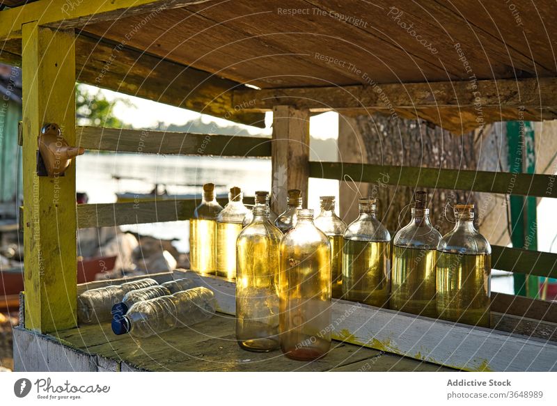 Flaschen mit Öl im Regal auf dem Land Erdöl Landschaft ländlich Ernährung hölzern schäbig Glas rustikal organisch sonnig Gegend natürlich Nutzholz tagsüber Holz