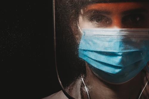 Weibliche Heldenärztin mit Maske und Schild auf schwarzem Hintergrund 2020 Atemschutzmaske schwarzer Hintergrund filmisch Klinik Korona-Epidemie Corona-Virus