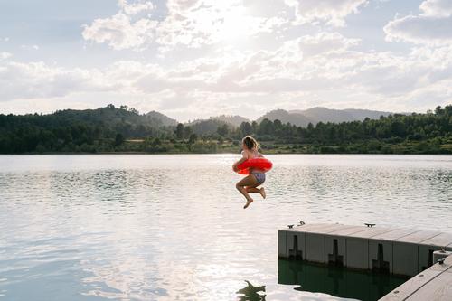 Mädchen springt mit aufblasbarem Ring in den See springen Gummi Teich Bikini Sommer Urlaub Spaß haben Teenager Moment Wasser Glück Erholung sich[Akk] entspannen