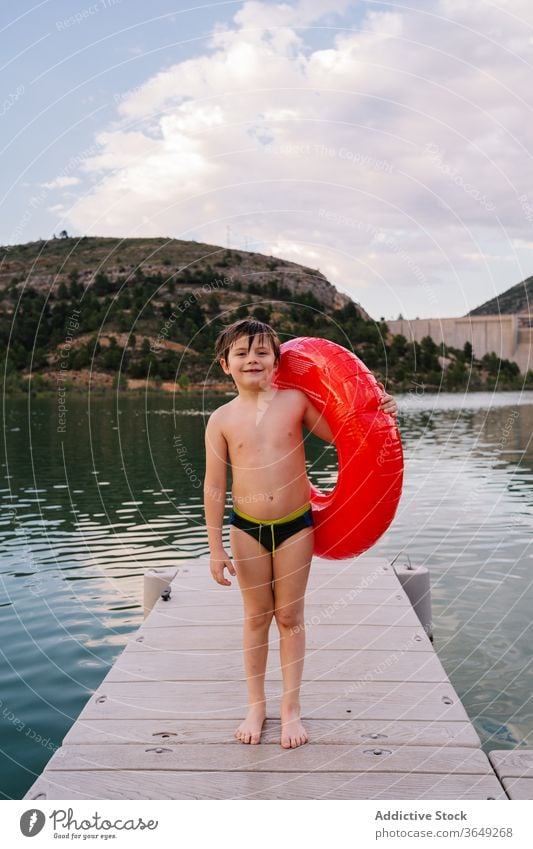 Junge mit aufblasbarem Ring im See Gummi Teich Sommer Urlaub niedlich Lächeln Spaß haben Kind Wasser Glück unschuldig heiter Kindheit sich[Akk] entspannen