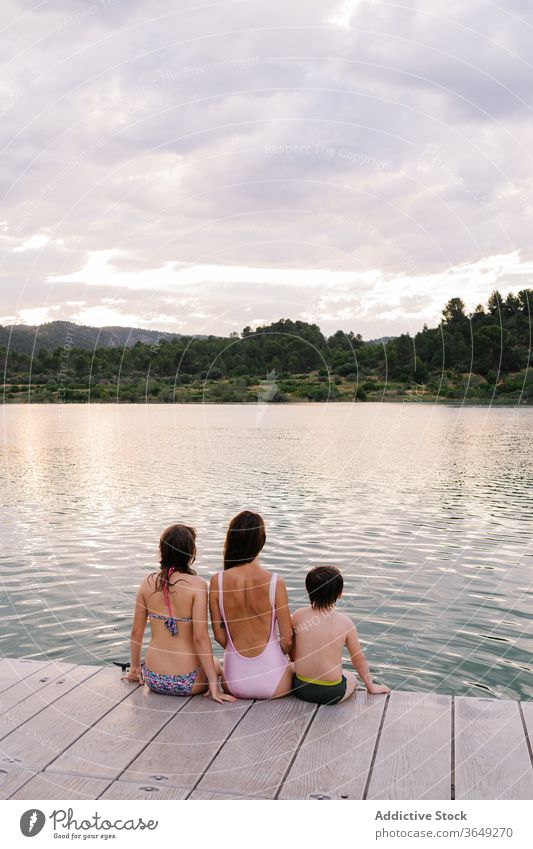 Ruhige Kinder, die einen herrlichen Blick auf den See genießen Urlaub Sommer bewundern Windstille Teich Badebekleidung Geschwisterkind Landschaft majestätisch