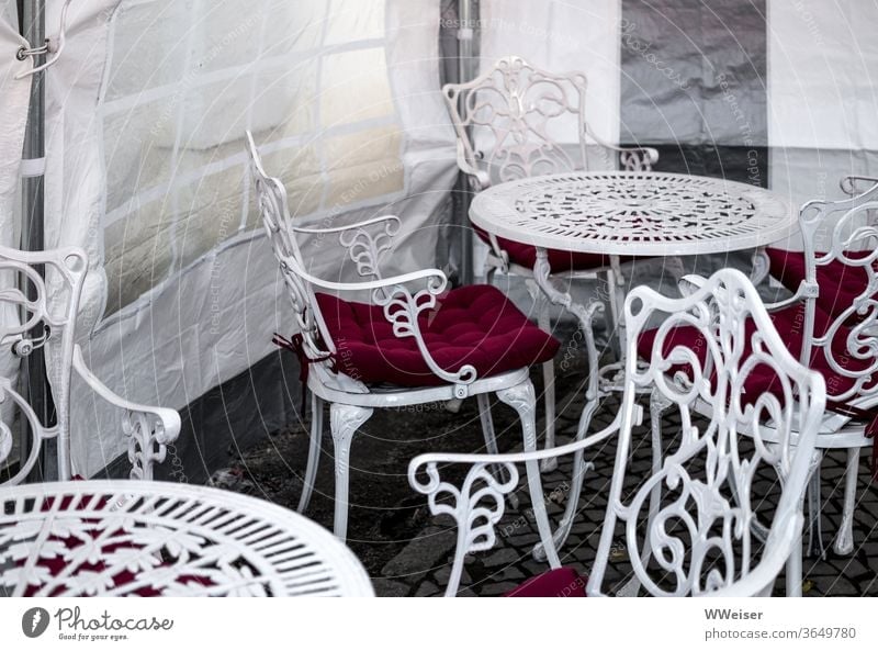 Die Eissaison fällt ins Wasser Eiscafe Stühle Tische Wintergarten Café verregnet kalt Ornament Vintage verziert Gartenmöbel Windschutz Zelt überdacht leer
