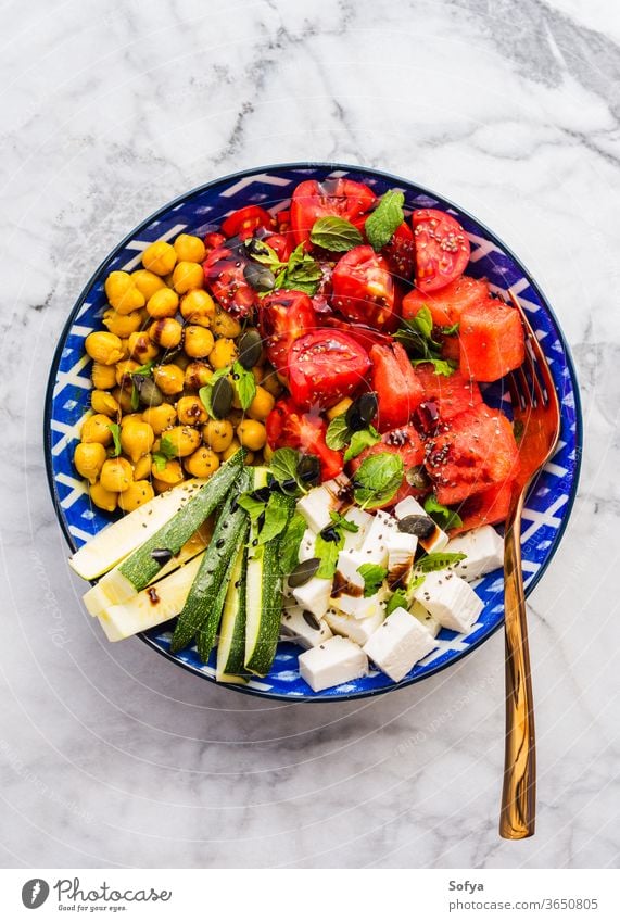 Kichererbsen-Wassermelonensalat mit Feta und Tomaten Lebensmittel farbenfroh Salatbeilage Kurkuma Käse Draufsicht flache Verlegung Zucchini Minze balsamisch
