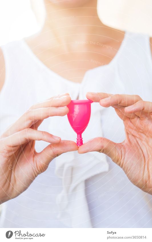 Frau hält eine Menstruationstasse in der Hand Tasse menstruell Hände keine Verschwendung Produkt Aussehen Beteiligung rosa Hygiene wiederverwendbar Silikon