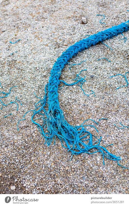 Gerissenes blaues Seil Tau gerissen Straße Asphalt kaputt liegen Belastungsgrenze fransen maritim Außenaufnahme Hafen Farbfoto Menschenleer versagt Tag