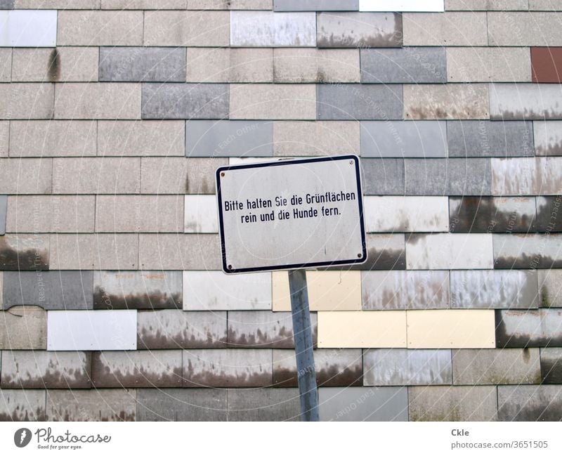 Wiener Schild Anweisung Gebote Befehl Anordnung Fassade Muster Grau Tristesse Grünfläche Hunde grau Architektur Gebäude Außenaufnahme trist Mauer Farbfoto