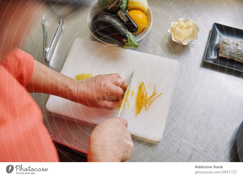 Ernte nicht erkennbar Koch schält Zitrone während der Zubereitung von Fischgarnitur Schale Küchenchef vorbereiten geschnitten Lebensmittel kulinarisch