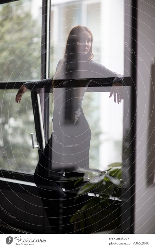 Attraktive Frau hinter Glastrennwand eine Person Mädchen Junge Frau Silhouette Dreiviertellänge Fenster Kontemplation Gedanke Wegsehen Kopf gedreht