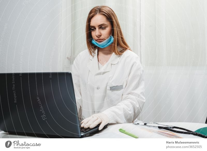 Ärztin mit Maske arbeitet am Laptop in der Arztpraxis 2020 Atemschutzmaske schwarzer Hintergrund Klinik Korona-Epidemie Corona-Virus covid-19 covid-19-Test