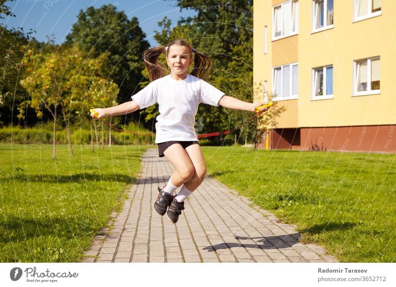 kleines Mädchen springt Seil nach draussen springen Kind niedlich schön wenig weiß Spaß hübsch heiter Lifestyle Kindheit spielen Menschen Kaukasier Freude