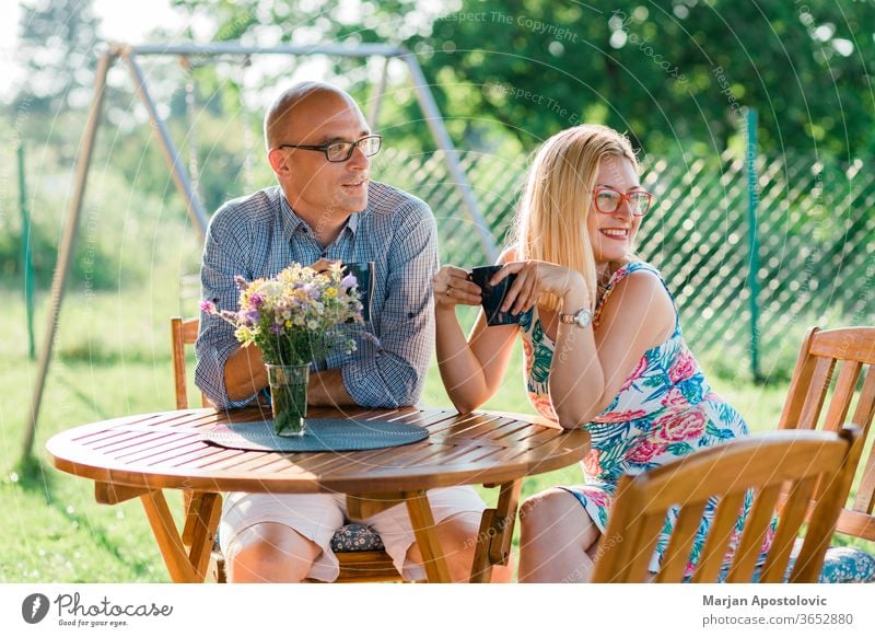 Junges Paar trinkt morgens Kaffee im Hinterhof Erwachsener lässig Kaukasier heiter Mitteilung Land Tag trinken genießend Abend Familie Frau Garten Mädchen