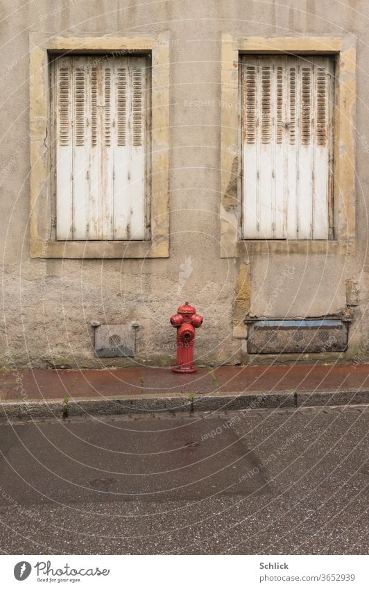 Hausfassade in Lothringen Metz mit Hydrant bei Regenwetter Fenster Fassade zwei Klappläden geschlossen Faltschiebeladen zu Straße Asphalt Bürgersteig Bordsteine
