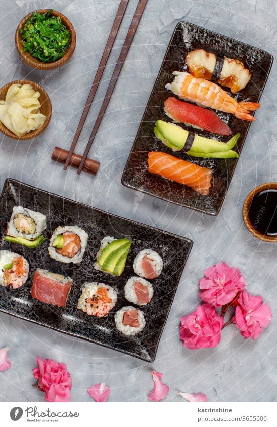 Sushi-Set Nigiri und Sushi-Rollen auf rechteckigen Tellern verzehrfertig Essen Sashimi Brötchen maki Sushi-Bar Esszimmer Japanische Kultur Meeresfrüchte