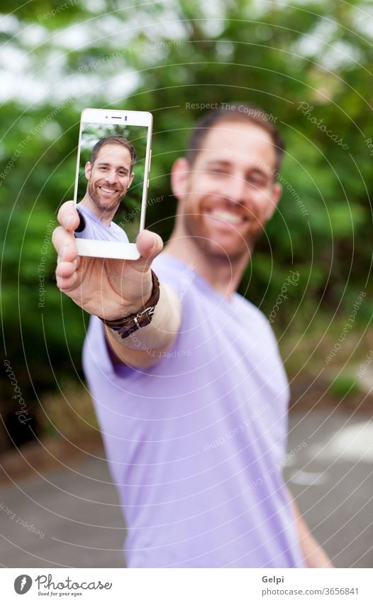 Lässiger Typ in einem Park beim Fotografieren Person Mann Mobile Telefon Lifestyle jung Porträt Selfie Technik & Technologie Glück modern Bild männlich