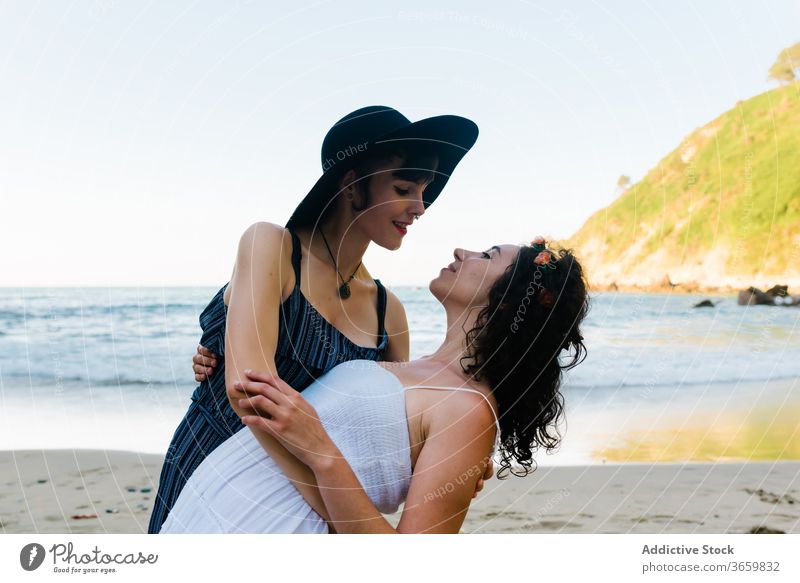 Nicht wiedererkennbares lesbisches Paar umarmt und küsst sich an sandiger Meeresküste Frauen Kuss Liebe sinnlich Partnerschaft Romantik Strand MEER