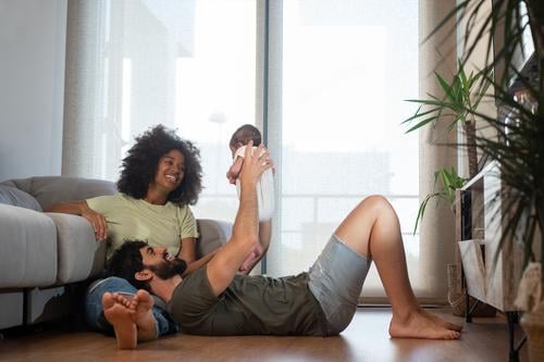 Glückliche multiethnische Familie entspannt zu Hause Einheit sich[Akk] entspannen heimwärts Zusammensein spielen Baby neugeboren bezaubernd Inhalt Spaß haben